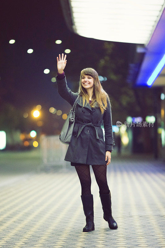 Young woman hailing a taxi